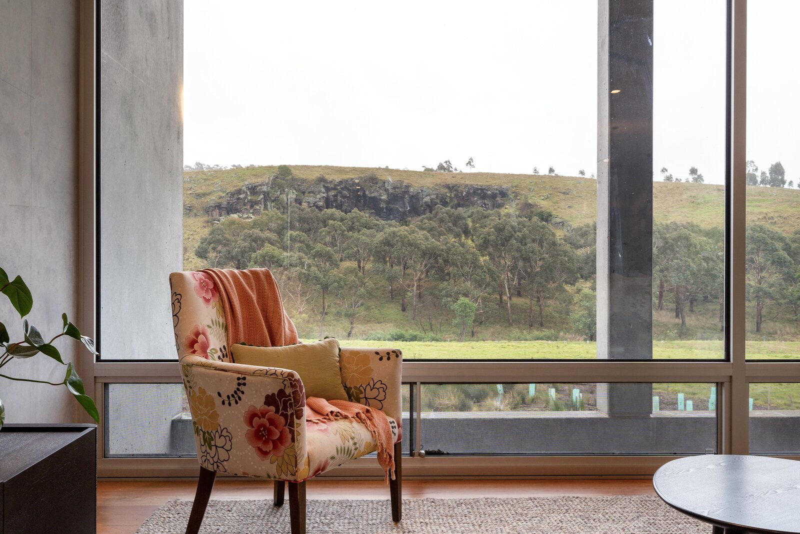 Floral chair overlooking the escarpment from inside the house at Mirrim Wurnit